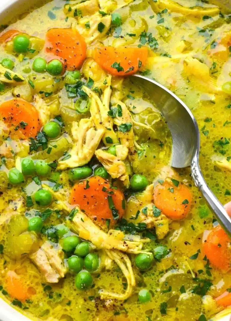Bowl of healing turmeric chicken soup with fresh herbs and spices