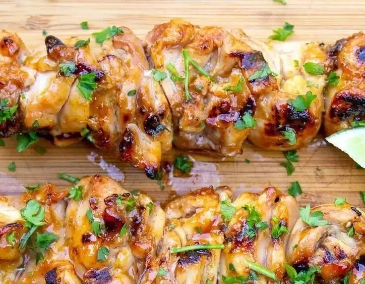 Spicy honey-lime chicken garnished with fresh herbs on a plate