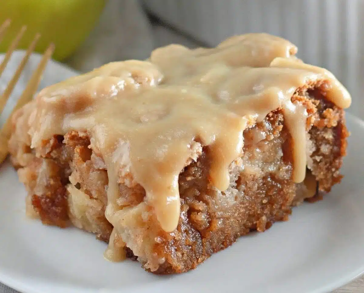Slice of easy apple dapple cake topped with brown sugar glaze