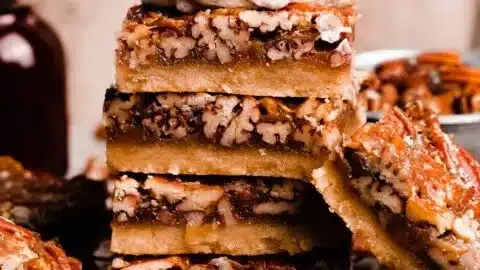 Easy salted maple pecan pie bars topped with pecans and a drizzle of maple syrup