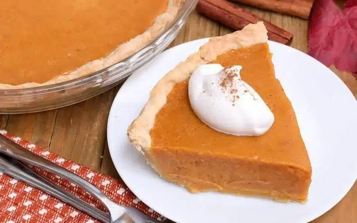 Slice of easy sweet potato pie on a plate with whipped cream
