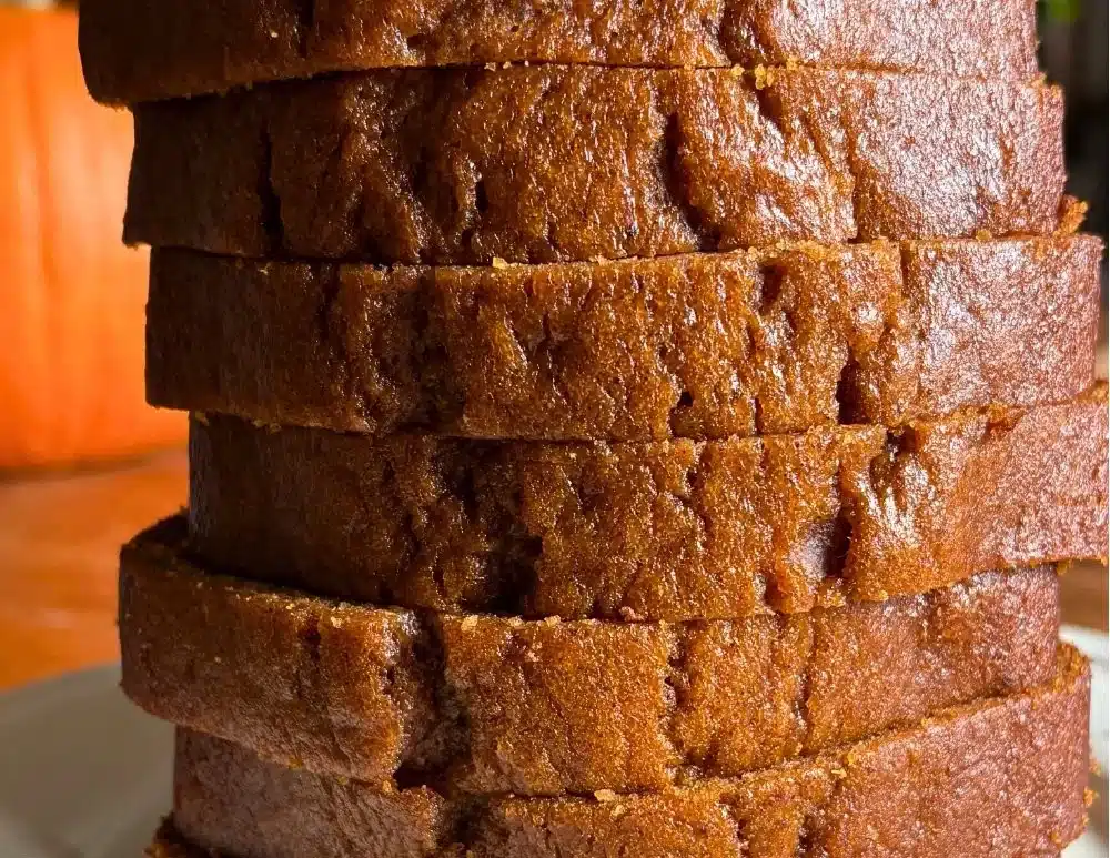 Delicious one-bowl pumpkin loaf topped with spices and served on a rustic table