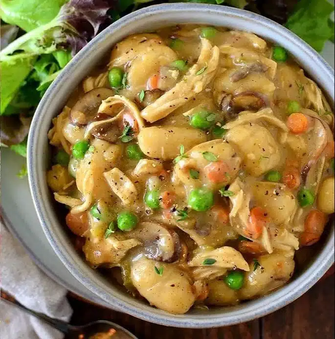 One-pot chicken pot pie topped with gnocchi, served in a rustic bowl