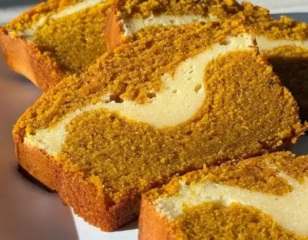 Delicious Pumpkin Cheesecake Bread displayed on a wooden table with fall decorations.