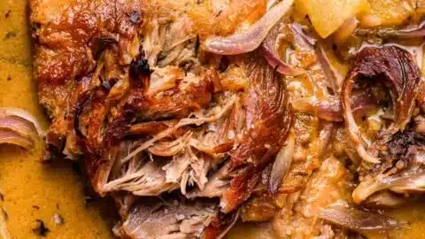 Delicious apple cider braised pork shoulder served with fresh herbs.